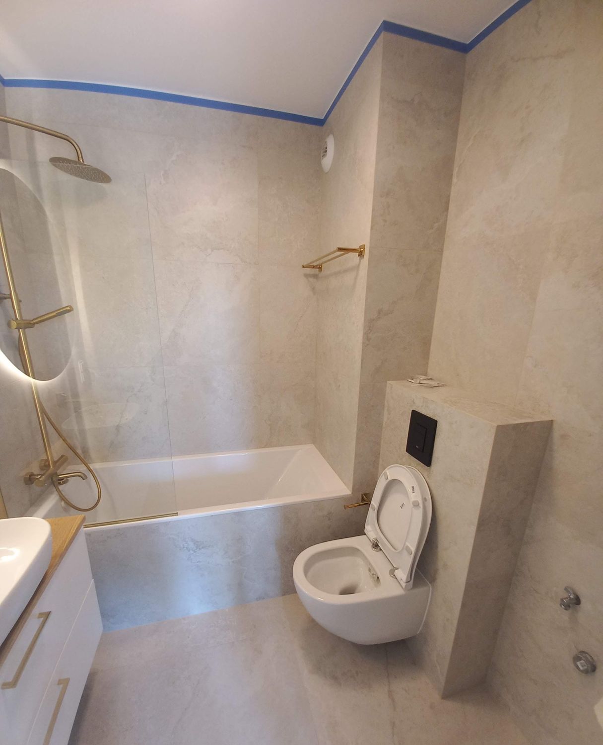 Łazienka z wanną, umywalką i WC po białym montażu