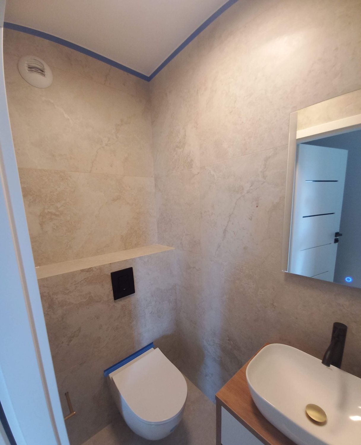 Łazienka po białym montażu z obudową WC i lustrem