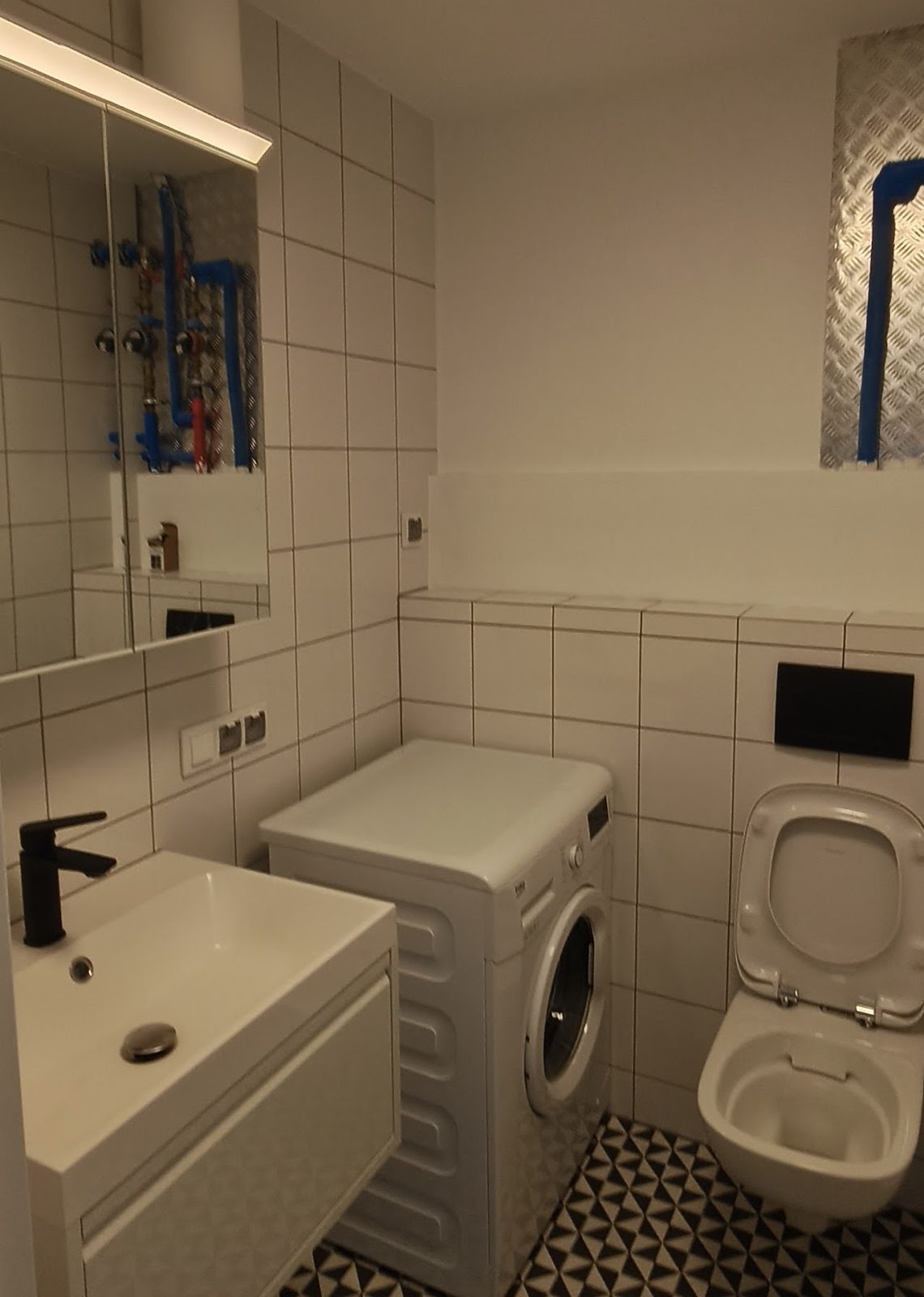 Łazienka po remoncie z umywalką, WC i zabudową instalacyjną