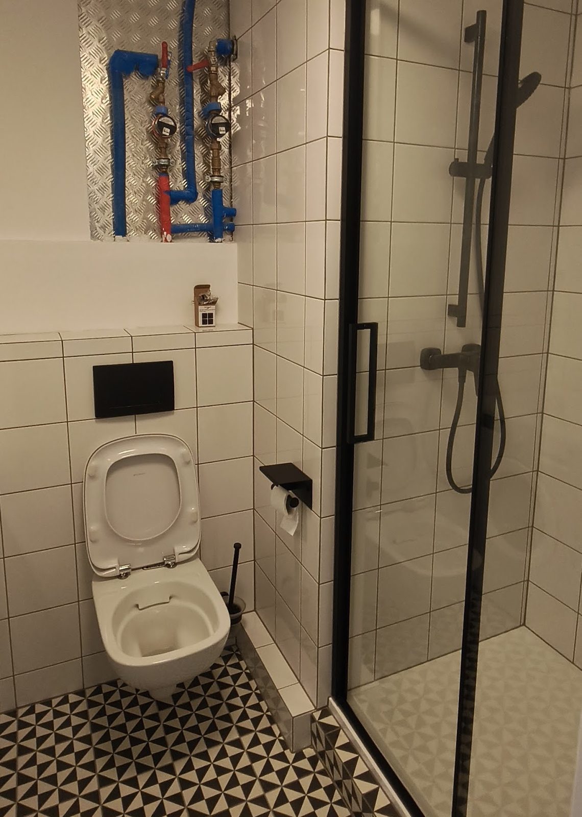 Łazienka po remoncie z kabiną prysznicową i czarną armaturą